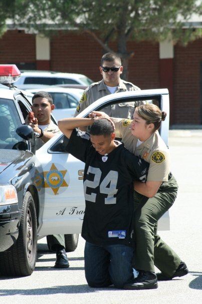 Deputies Arresting Youth in Football Jersey